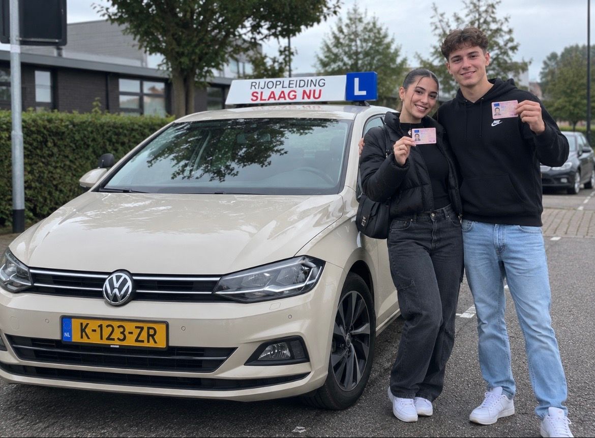 Twee geslaagde leerlingen met hun rijbewijs naast de lesauto van Rij-opleiding Slaag NU