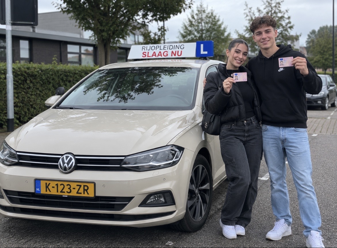 Twee geslaagde leerlingen met hun rijbewijs naast de lesauto van Rij-opleiding Slaag NU